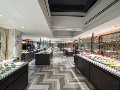 Ein modernes und luxuriöses Buffetrestaurant an Bord der Riverside Mozart. Die lange Theke ist reichlich mit Salaten, Früchten und Desserts bestückt. Der Boden hat ein elegantes Fischgrätmuster.