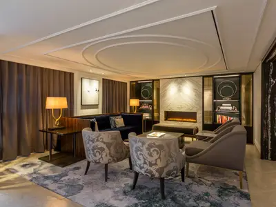 Elegante Lounge an Bord der Riverside Mozart mit Sofas, Sesseln, einem modernen Kamin und Bücherregalen. Der Raum ist stilvoll eingerichtet und warm beleuchtet.