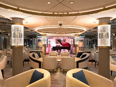Der luxuriöse Palm Court auf der Riverside Ravel bietet einen Flügel und stilvolle Sitzgruppen. Die Säulen sind mit leuchtenden Glaselementen verziert.