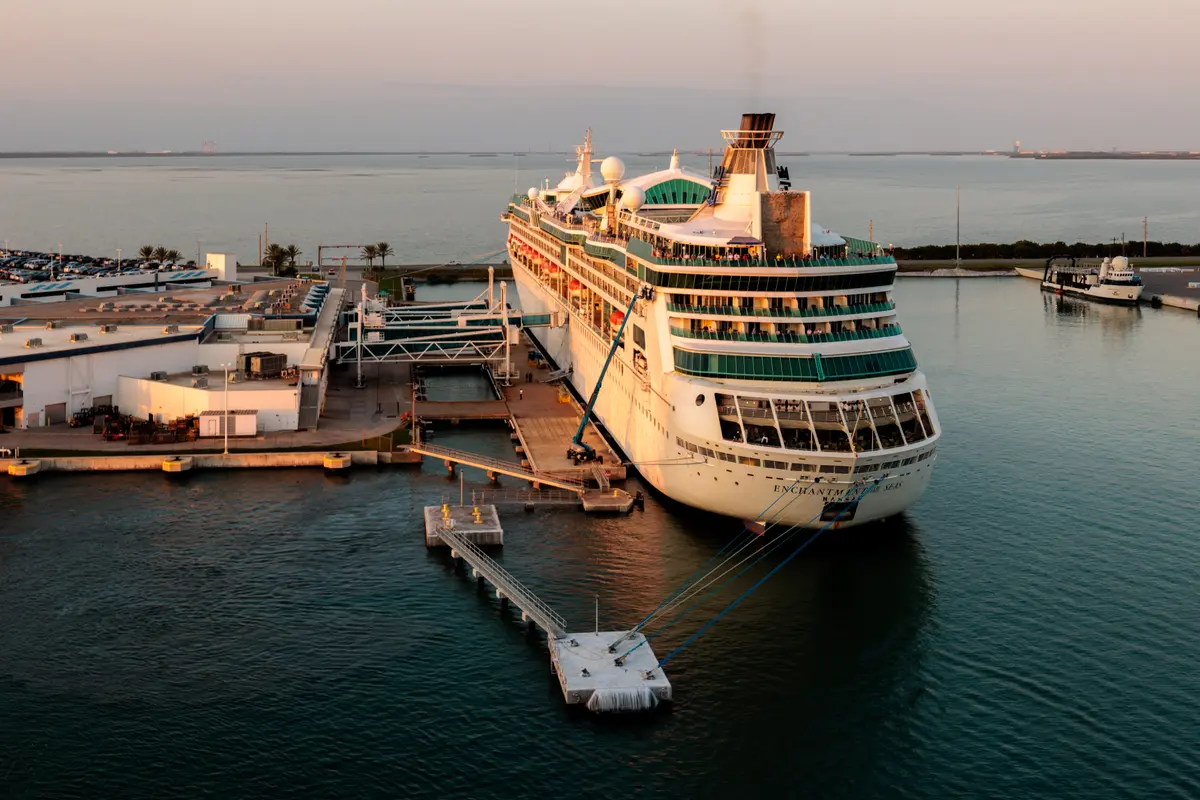 Luftaufnahme des Kreuzfahrtschiffs Enchantment Of The Seas, das bei Sonnenuntergang im Hafen am Pier liegt.