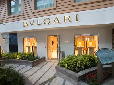 BVLGARI Boutique im Central Park der Harmony of the Seas. Beleuchtetes Logo, Schmuckdisplays. Umgeben von Pflanzen und gepflastertem Weg. Ein luxuriöses Detail an Bord.