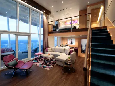 Eine luxuriöse, zweistöckige Suite auf der Harmony of the Seas mit raumhohen Fenstern zum Meer, einem Wohnbereich unten, einem Schlafzimmer oben auf der Galerie und einem privaten Balkon.