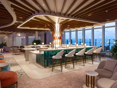 Moderne Bar und Lounge an Bord der Icon of the Seas. Ein langer Bartresen mit Hockern und Sitzgruppen ist zu sehen. Große Fenster zeigen den Meerblick. Die einzigartige Decke hat Holzlamellen und Lichtelemente.