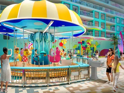 Ein lebhaftes Kinderkarussell mit lachenden Kindern auf der Legend of the Seas. Bunte Spielflächen und moderne Gebäude prägen diesen Deckbereich.