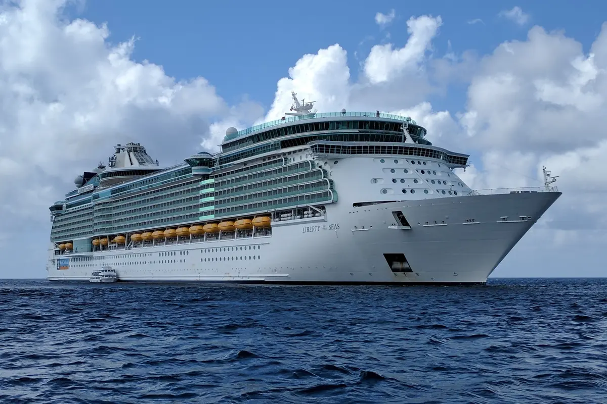 Seitenansicht der Liberty Of The Seas auf dem offenen blauen Meer unter leicht bewölktem Himmel.