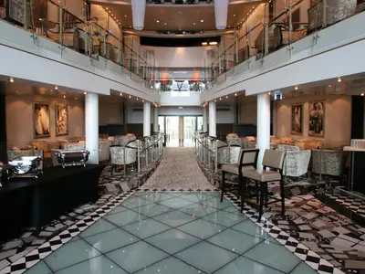 Die luxuriöse, mehrstöckige Lounge auf der Oasis of the Seas, mit Glasboden, eleganten Sitzgruppen und Buffetstationen.