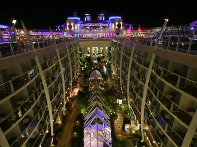 Nachtaufnahme des Central Park auf der Oasis of the Seas. Beleuchtete Kabinen säumen den Park mit Wegen, Pflanzen und Pavillons.