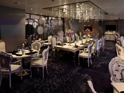 Restaurant auf der Ovation of the Seas: fantasievolle Stühle, gedeckte Tische und eine einzigartige Deckeninstallation.