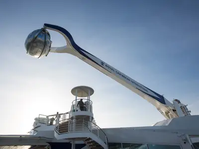 Die North Star-Beobachtungsgondel an einem Kranarm auf der Quantum of the Seas. Darunter ist ein Teil des Decks mit einer Plattform zu sehen.