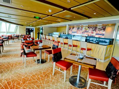 Innenansicht eines Restaurants an Bord der Radiance of the Seas. Der Raum zeigt Tische mit roten Stühlen, gemusterten Teppich, eine Bar mit Hockern und große Fenster.