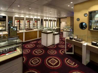 Luxuriöser Uhren- und Schmuckladen auf der Spectrum of the Seas. Vitrinen zeigen Uhren und Schmuck bekannter Marken. Roter, gemusterter Teppichboden.