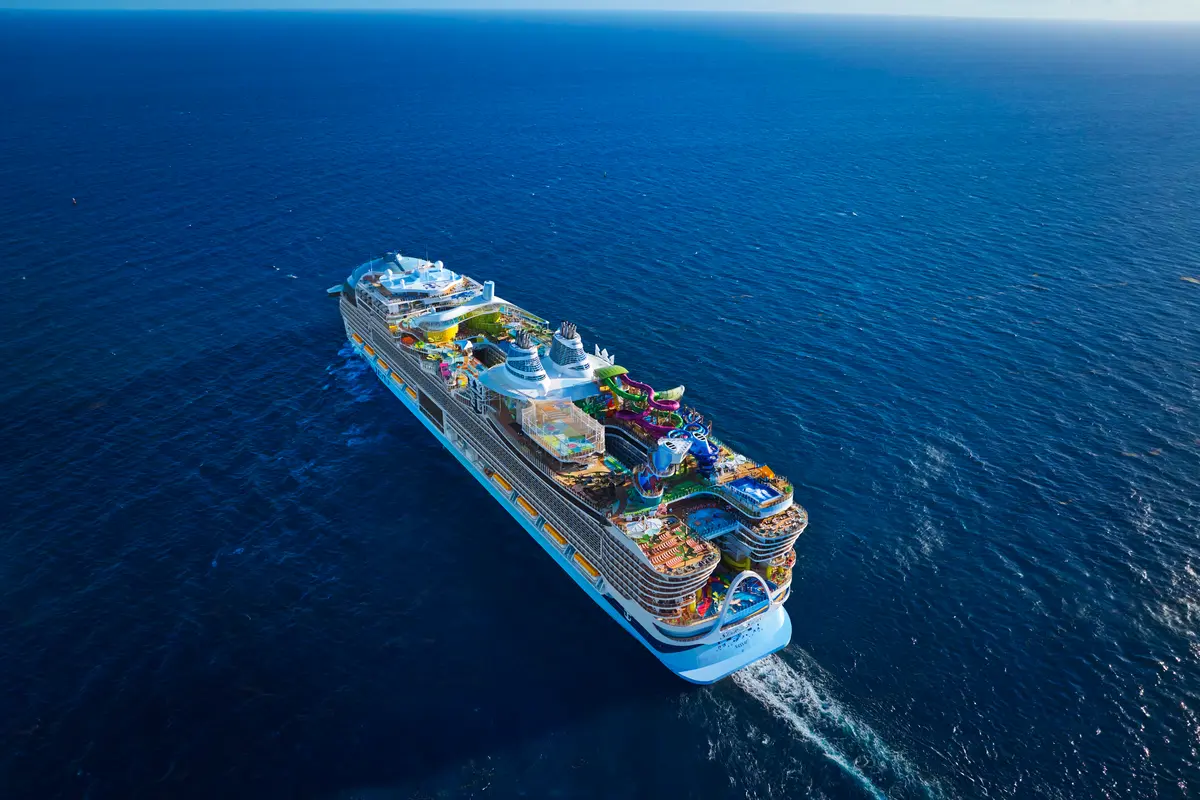 Luftaufnahme der Star of the Seas auf blauem Meer. Das Schiff hat bunte Wasserrutschen, Pools und viele Freizeiteinrichtungen an Deck.