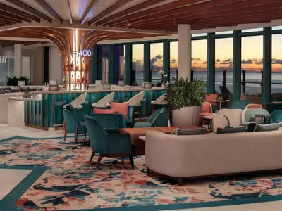 Blick in die moderne Bar und Lounge der Star of the Seas. Teal-farbene Theke, bequeme Sitzmöbel, große Fenster mit Meer- und Sonnenuntergangsblick.