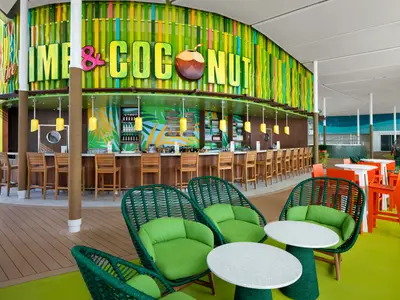 Die lebhafte Lime & Coconut Bar auf der Star of the Seas mit Holzhockern, tropischer Wandgestaltung, grünen Sitzmöbeln und orangefarbenen Tischen und Stühlen.