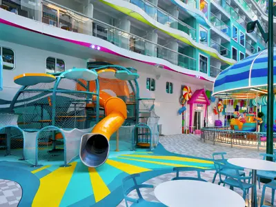 Das Deck der Star of the Seas mit einem farbenfrohen Kinderspielplatz samt Rutsche, einem 'Sugar'-Laden mit Lollipop-Dekoration und einem kleinen Karussell.
