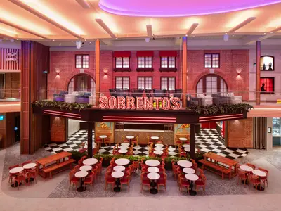 Innenansicht des Restaurants Sorrento's auf der Star of the Seas. Es zeigt einen Essbereich mit kariertem Boden und Lounge-Ebene.