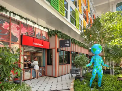Restaurantbereich der Star of the Seas. Izumi In The Park und Sushi-Stand. Blaue Erdball-Statue zwischen Pflanzen, bunte Fenster.
