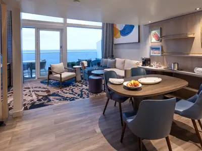 Einblick in eine luxuriöse Suite der Star of the Seas mit Wohnzimmer, Essbereich, vollausgestatteter Bar und Meerblick-Balkon.