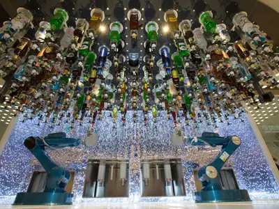 Futuristische Bionic Bar auf der Symphony of the Seas mit zwei Cocktail-Robotern. Über 100 hängende Flaschen und ein funkelnder LED-Tresen.