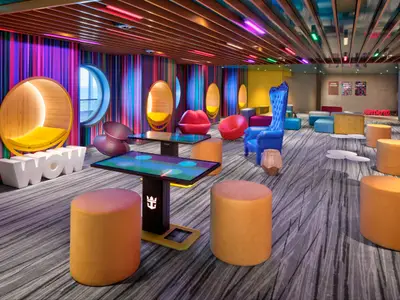 Bunte Lounge auf der Wonder of the Seas mit gestreiften Wänden, leuchtenden Deckenleisten und vielfältigen Sitzmöbeln. Interaktive Tische und runde Alcoven sind zu sehen.