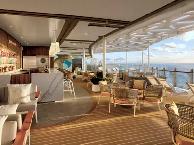 Ein sonniger Außenbereich an Bord der Wonder of the Seas mit einer gut bestückten Bar, gemütlichen Sitzgelegenheiten und Panoramablick auf das offene Meer.