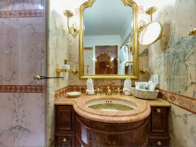 Elegantes Badezimmer aus rosa Marmor mit Goldarmaturen in einer Kabine an Bord der Sea Cloud Ii.