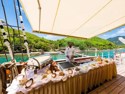 Ein Koch steht an einem mit Meeresfrüchten und Muscheln dekorierten Lido-Buffet auf der Sea Cloud Ii.