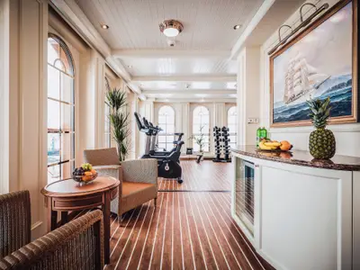 Der helle Fitnessbereich an Bord der Sea Cloud Spirit bietet Cardio-Geräte, Hanteln, Obst und Seeblick.