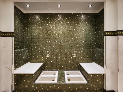 Elegantes Fußbad mit grünen Mosaikfliesen und Bänken im Spa-Bereich an Bord der Sea Cloud Spirit.