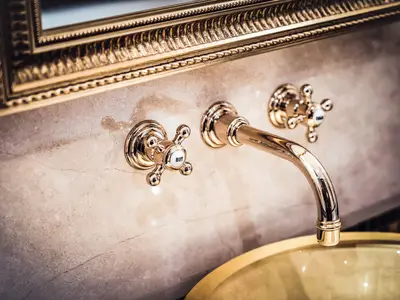 Nahaufnahme einer goldenen Mischbatterie und Marmorwand im Badezimmer an Bord der Sea Cloud Spirit.