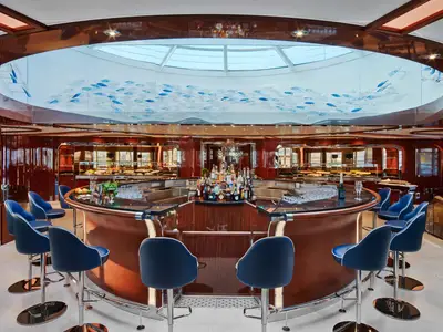 Die kreisrunde Bar an Bord der Seabourn Encore zeichnet sich durch blaue Barhocker und eine kunstvolle Deckeninstallation aus.