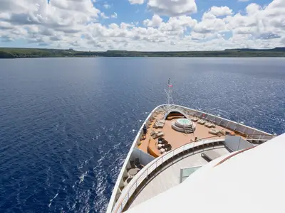 Vogelperspektive auf den Bug der Seabourn Encore mit einem Whirlpool, Liegestühlen und weitem Meerblick.