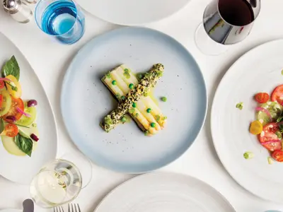 Draufsicht auf elegant angerichtete Speisen im Restaurant an Bord der Seabourn Encore mit weißem Spargel.