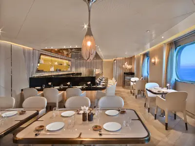 Ein elegant eingerichtetes Sushi-Restaurant an Bord der Seabourn Encore mit gedeckten Tischen und Blick durch ein großes Fenster auf das Meer.
