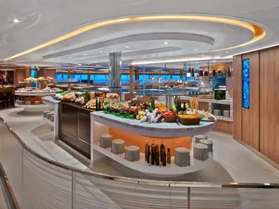 Das elegante Buffet-Restaurant The Colonnade an Bord der Seabourn Encore mit frischen Speisen und warmen Lichtelementen.