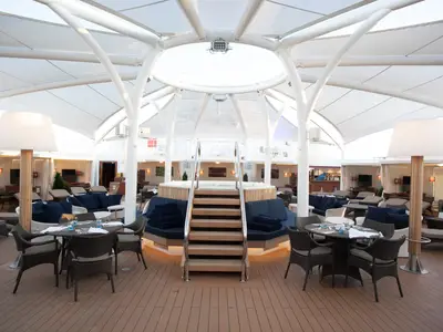 Der luxuriöse Loungebereich „The Retreat“ an Bord der Seabourn Encore mit einem zentralen Whirlpool unter einem Sonnensegel.
