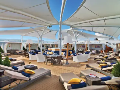 Luxuriöses Sonnendeck 'The Retreat' an Bord der Seabourn Encore mit gemütlichen Lounge-Sitzgruppen, Liegestühlen und weißen Sonnensegeln.