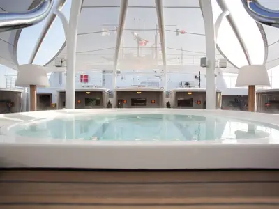 Ein großer Whirlpool unter einem hellen Sonnensegel im exklusiven Retreat-Bereich an Bord der Seabourn Encore.