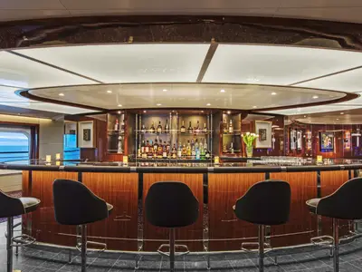 Die stilvolle Bar an Bord der Seabourn Ovation lädt mit dunklen Leder-Barhockern und feiner Holztäfelung zum Verweilen ein.