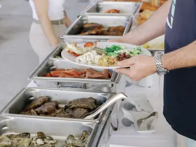 Ein Gast bedient sich am reichhaltigen Buffet mit Meeresfrüchten und Fleisch an Bord der Seabourn Ovation.