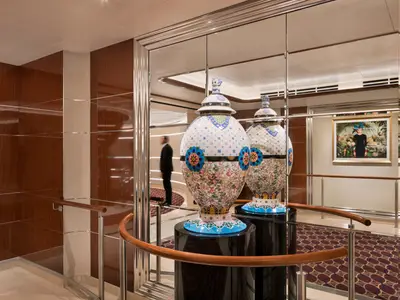 Eine prachtvolle, bunt verzierte Keramikvase vor einer Spiegelwand an Bord des Luxusschiffs Seabourn Ovation.