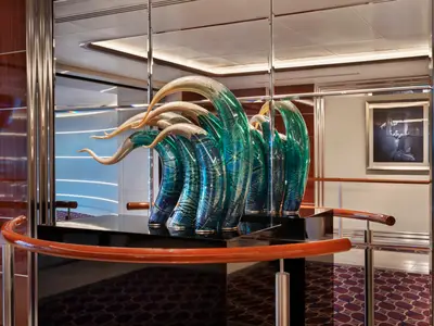 Ein elegantes, geschwungenes Glaskunstwerk in Blau und Grün an Bord der Seabourn Ovation.