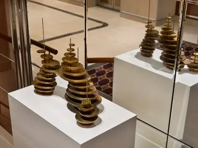 Nahaufnahme einer modernen Messing-Skulptur auf einem weißen Sockel an Bord der Seabourn Ovation.