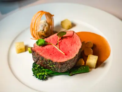 Ein perfekt angerichtetes, rosa gebratenes Rinderfilet mit Beilagen im Restaurant an Bord der Seabourn Ovation.