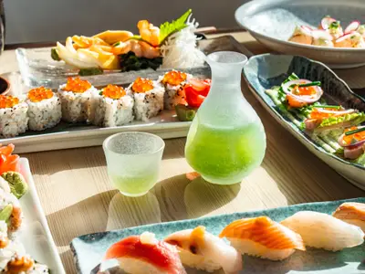 Nahaufnahme von frisch zubereitetem Sushi, Sashimi und Sake an Bord der Seabourn Ovation.