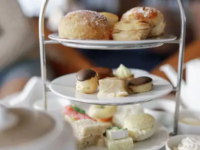 Eine dreistöckige Etagere mit feinem Gebäck, Törtchen und Sandwiches für den Afternoon Tea an Bord der Seabourn Ovation.