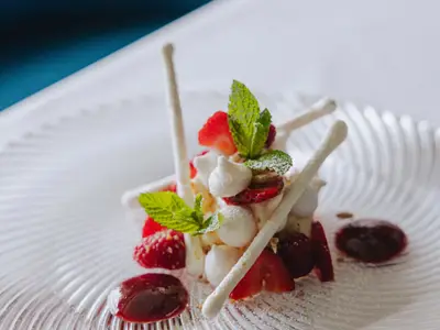 Ein kunstvoll angerichtetes Dessert mit frischen Beeren und Baiser-Elementen an Bord der Seabourn Ovation.