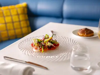 Ein elegant angerichteter Salat auf einem strukturierten Glasteller im Restaurant an Bord der Seabourn Ovation.