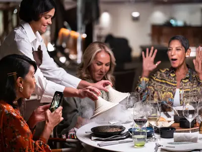 Eine Kellnerin serviert Gästen an Bord der Seabourn Ovation ein dampfendes Gericht in einem eleganten Restaurant.