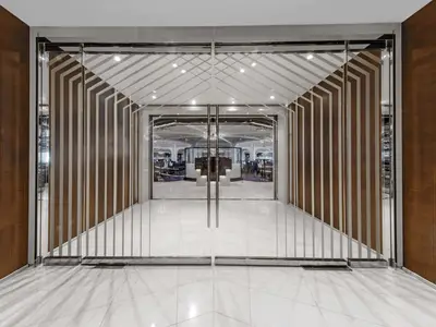 Symmetrischer Blick durch verglaste Flügeltüren in ein elegantes Restaurant an Bord der Seabourn Ovation mit Linien-Design und weißem Boden.